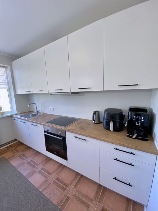 Balta virtuves iekārta ar koka imitācijas virsmu